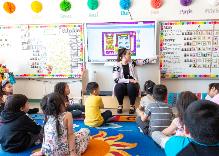 Children listening to the teacher in a classroom.