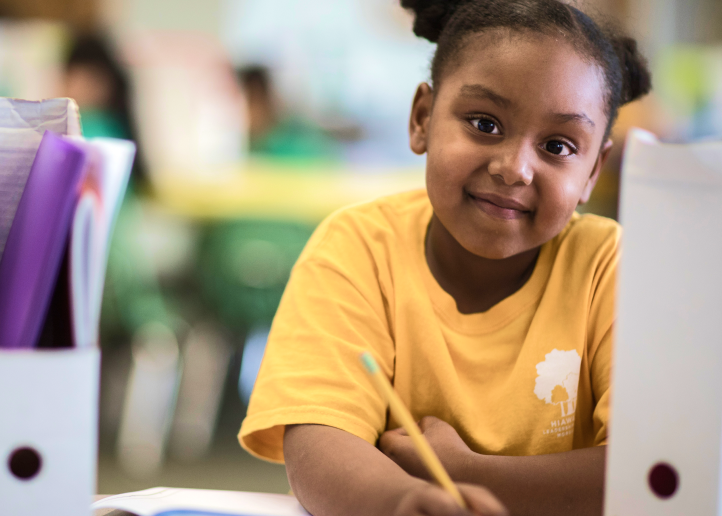 Child writing at their desk at school.